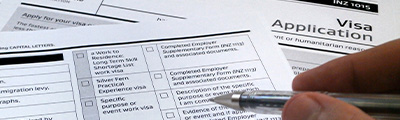 An image of a visa application and pen