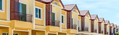A close up photo of a row of yellow two storey town houses